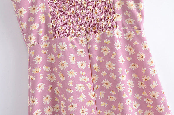 Roze zomerjurk met madeliefjesprint en gesmokte bovenkant, perfect voor casual lente- en zomermode. Trendy bloemenjurk voor dames.