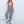 Vrouw in roze crop top en zwart-wit geruite broek, gecombineerd met witte laarzen. Modieuze streetwear outfit, trendy dameskleding.