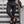 Man in geruite broek en loafers op stenen trap, stijlvolle herenkleding, moderne mode, casual outfit, stedelijke achtergrond.