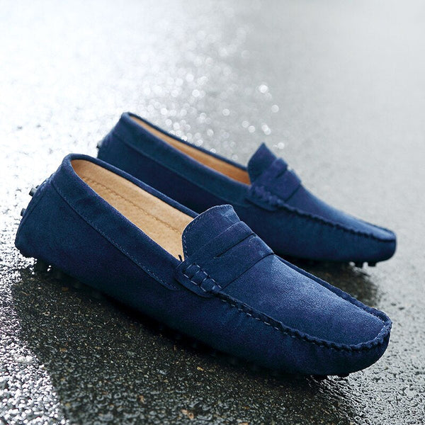 Blauwe suède loafers voor heren op natte ondergrond, stijlvolle casual schoenen, comfortabele pasvorm, ideaal voor dagelijks gebruik en modebewuste mannen.