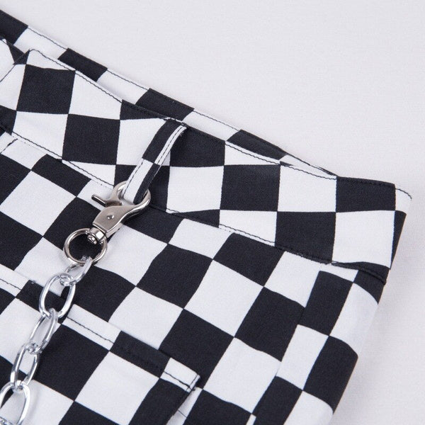 Zwart-wit geruite broek met metalen ketting, trendy streetwear mode, close-up detail, hippe stijl, unisex kleding, moderne outfit.