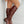Bruine leren dameslaarzen met lage hak, gedragen door model. Stijlvolle kniehoge laarzen, perfect voor herfstmode en casual outfits.