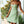 Vrouw in groene zomerjurk met bloemenprint, staand op veranda. Trendy damesmode, casual lente- en zomerkleding, stijlvolle outfit.