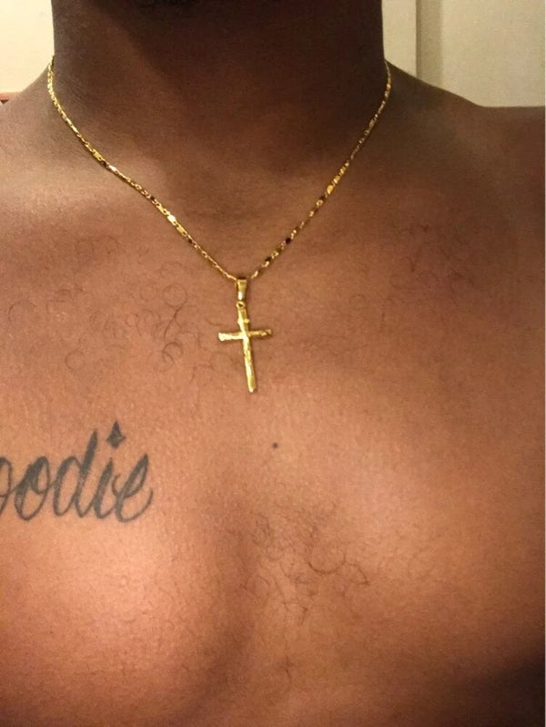 Gouden kruis ketting op mannelijke borst met tatoeage, minimalistisch ontwerp, populaire sieraden, stijlvolle accessoires, modetrend.