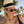 Vrouw met zwarte vintage zonnebril en witte hoed, strandachtergrond. Hipster stijl, retro mode, zomeraccessoires, dames zonnebrillen.