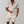 Man in beige zomerset met geometrisch patroon, korte mouwen en korte broek, drinkt een drankje. Stijlvolle herenkleding voor de zomer.