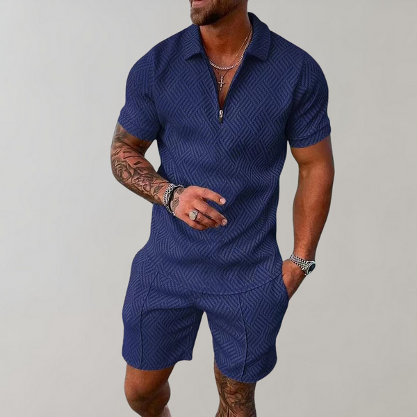 Man in donkerblauw zomerset voor heren met geometrisch patroon, korte mouwen en korte broek. Modieuze herenkleding, casual zomeroutfit.