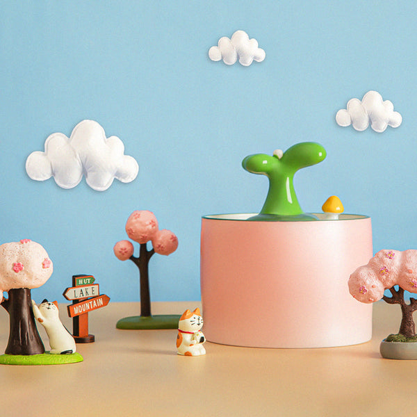 Roze kattenwaterfontein met groene spruit, omringd door decoratieve bomen en wolken. Perfect voor huisdieren, modern design, interieurdecoratie.