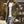 Man in groene lange jas, witte T-shirt en gescheurde jeans. Stijlvolle herenkleding, herfstmode, stedelijke achtergrond.