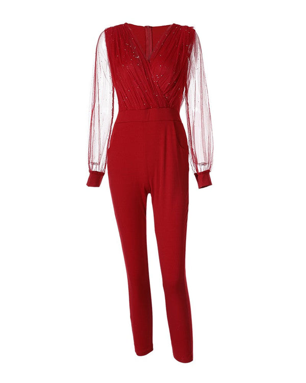 Rode jumpsuit met doorschijnende mouwen en glinsterende details, elegante avondkleding, modieuze dameskleding, trendy outfit voor speciale gelegenheden.
