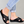 Zwarte comfortabele damesslippers met kruisbanden, gedragen door model met opgerolde spijkerbroek. Perfect voor casual zomeroutfits.