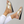 Gouden damesslippers met kruisbanden en zwarte zool, gedragen door vrouw in witte broek. Comfortabele zomerschoenen, modieuze sandalen.