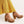 Dames khaki platformhakken met houten zool en kruisbandjes, gecombineerd met gele broek. Modieuze schoenen, trendy damesmode, comfortabele hakken.