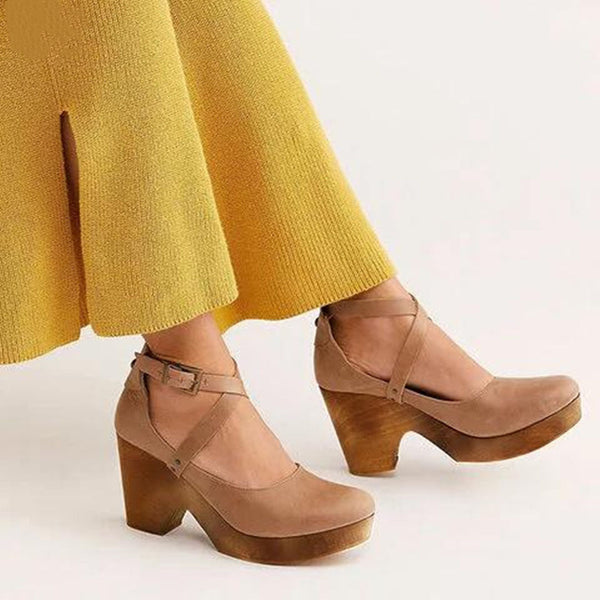 Dames khaki platformhakken met houten zool en kruisbandjes, gecombineerd met gele broek. Modieuze schoenen, trendy damesmode, comfortabele hakken.