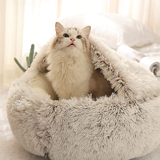 Kat in een zacht, beige kattenmandje, ideaal voor comfort en ontspanning. Perfect huisdieraccessoire voor kattenliefhebbers.