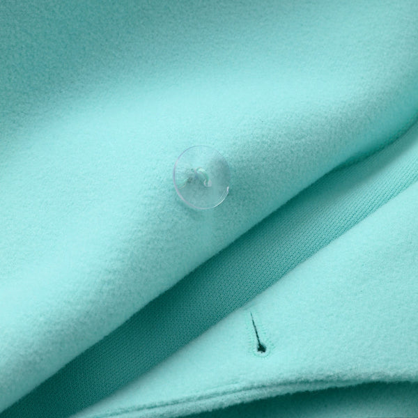 Lichtblauwe wollen stof met transparante knoop, close-up. Perfect voor modeontwerp, naaiprojecten en textieltoepassingen.