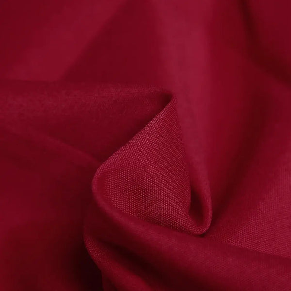 Rode stof close-up, textuur van een elegante, stijlvolle damestop met halternek. Perfect voor modieuze dameskleding en trendy outfits.