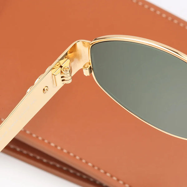 Gouden ovale zonnebril met metalen frame, stijlvolle dames- en herenaccessoire, luxe design, ideaal voor zomer, op bruine achtergrond.