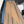 Drie leren rokken met riemen in zwart, blauw en beige op een grijze bank. Stijlvolle damesmode, trendy kleuren, elegante uitstraling.