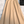 Beige A-lijn rok met riem op witte achtergrond, naast een zwarte leren handtas. Elegante damesmode, perfect voor casual en formele gelegenheden.