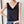Zwarte satijnen dames top met V-hals, gedragen met blauwe jeans. Elegante minimalistische stijl, perfect voor casual en formele gelegenheden.