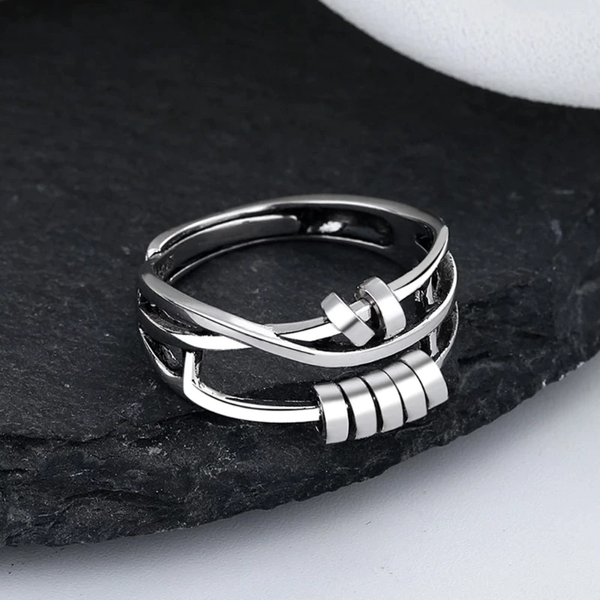 Zilveren ring met modern, geometrisch ontwerp op zwarte leisteen achtergrond. Stijlvolle sieraden, perfect voor modebewuste liefhebbers.