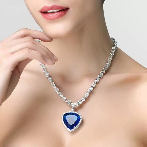 Vrouw met elegante halsketting, hartvormige blauwe saffier hanger, omringd door diamanten. Luxe sieraden, stijlvolle accessoires, mode.