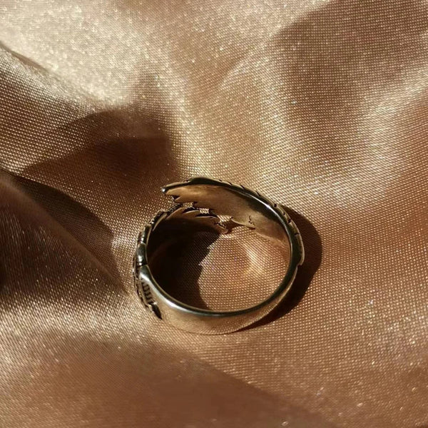 Zilveren haaienring op glanzende gouden stof, uniek sieradenontwerp, modieuze accessoires, perfect voor stijlvolle en trendy looks.