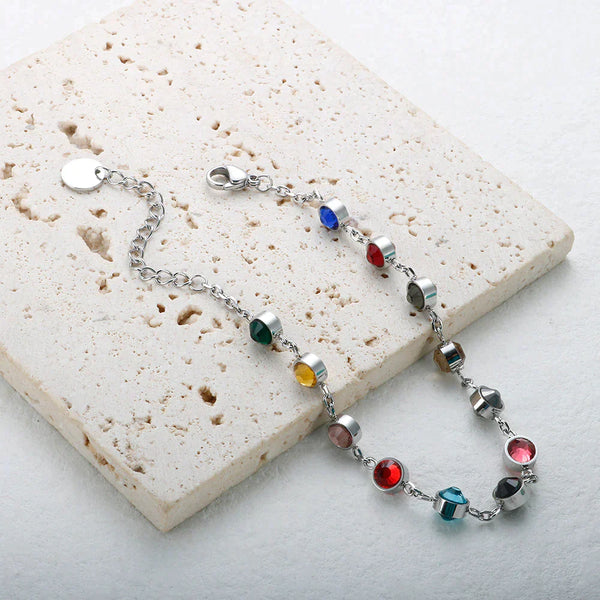 Zilveren armband met kleurrijke edelstenen op witte achtergrond, elegant sieraad, modieuze damesaccessoire, perfect voor elke gelegenheid.
