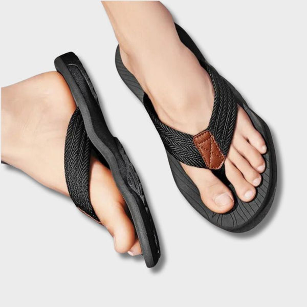 Zwarte orthopedische slippers met gevlochten band en bruine details, comfortabel voetbed, ideaal voor dagelijks gebruik. 50% korting aanbieding.