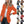 Vrouw in oranje blazer, witte top en zwarte broek. Verschillende kleuren blazers rechts. Mode, dameskleding, stijlvolle blazers.
