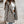 Vrouw in geruite blazer en witte crop top, casual mode, herfststijl, stedelijke achtergrond, trendy dameskleding, streetwear outfit.