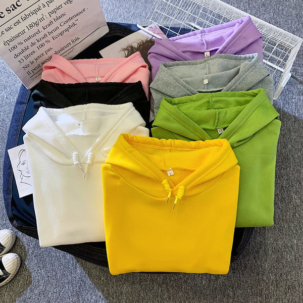 Zes kleurrijke hoodies op een grijze achtergrond, inclusief geel, wit, groen, zwart, roze en paars. Perfect voor casual mode en streetwear trends.