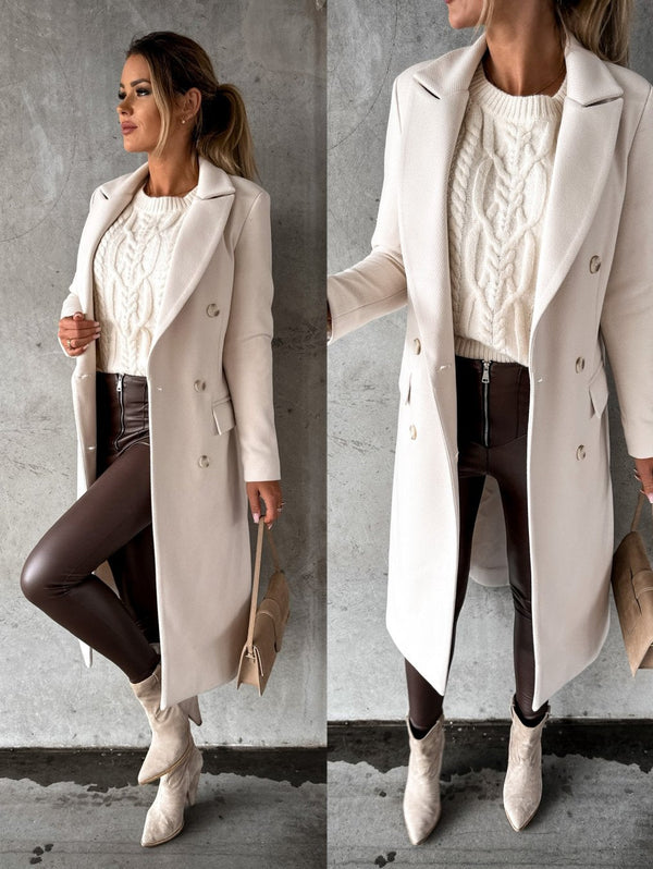 Vrouw in stijlvolle witte wollen jas met dubbele rij knopen, gecombineerd met gebreide trui en bruine leren broek. Perfecte herfst- en wintermode.