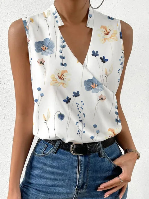Vrouw draagt witte mouwloze blouse met bloemenprint, V-hals en blauwe jeans. Zomer casual mode 2023, trendy dameskleding.
