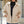 Vrouw in beige teddyjas met rits, zwarte coltrui en spijkerbroek. Modieuze winterkleding, casual stijl, comfortabele warme jas.