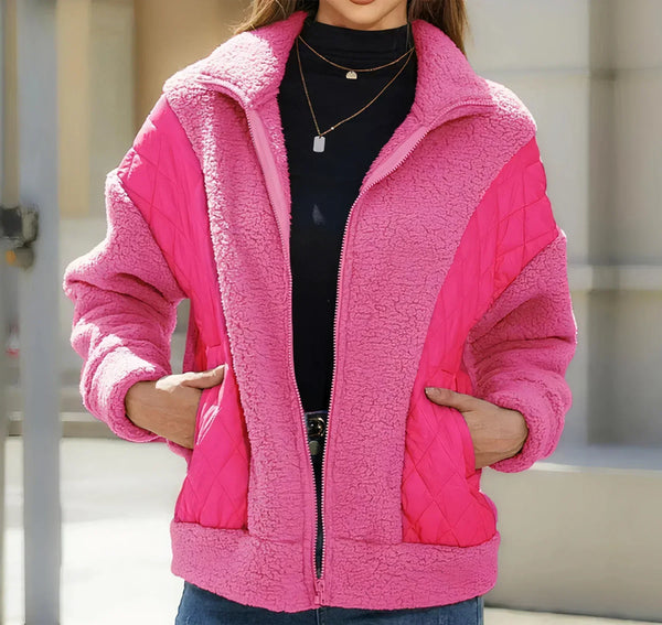 Vrouw draagt roze teddyjas met rits en gewatteerde panelen, modieuze winterkleding, trendy damesjas, warme en stijlvolle outfit voor koud weer.