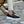 Bruine heren gevulkaniseerde schoenen met dubbele gesp, zwart slip-on design, handgemaakt, gedragen door model op stenen vloer.