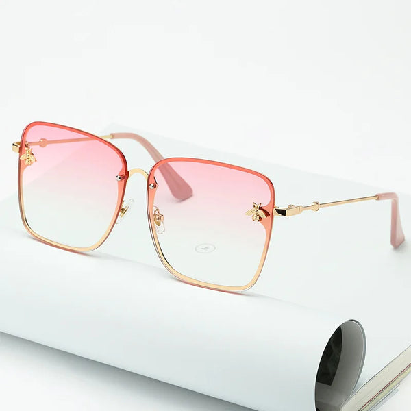 Oversized randloze vierkante zonnebril met bijendecoratie, roze gradiënt glazen. Modieuze damesaccessoire, unisex stijl, trendy zonnebril.