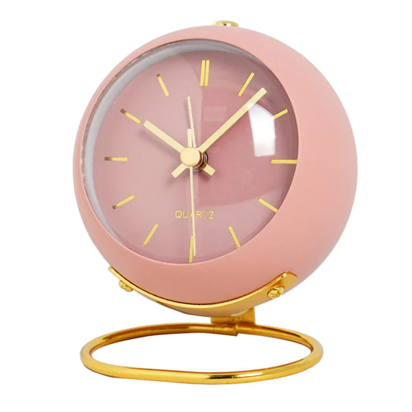 Roze ronde wekker met gouden wijzers en standaard, minimalistisch design, stille werking, ideaal voor kinderkamer of nachtkastje.