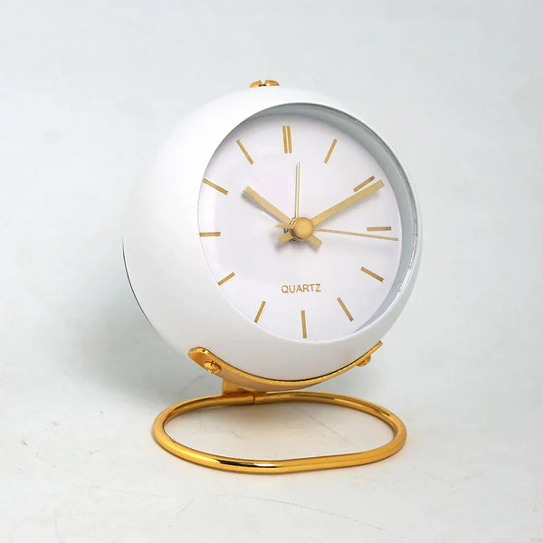 Minimalistische witte ronde wekker met gouden wijzers en standaard, stille kwartsmechanisme, ideaal voor nachtkastje of bureau, Scandinavisch design.