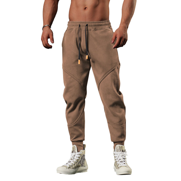 Bruine joggingbroek voor heren, sportief design, comfortabele pasvorm, ideaal voor fitness en casual wear, gecombineerd met witte sneakers.