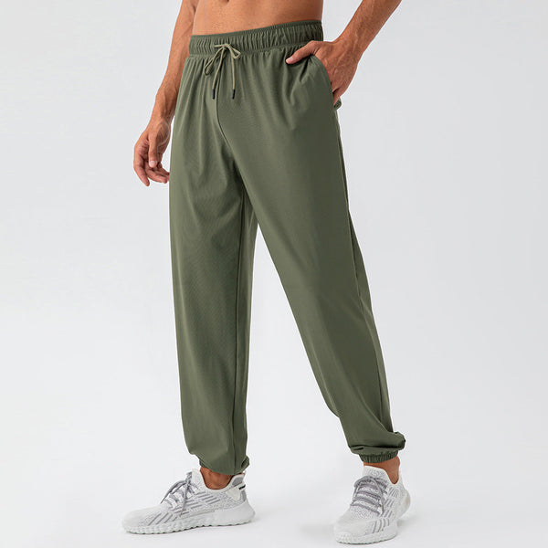 Groene sportbroek voor heren, gemaakt van ademend materiaal, met elastische tailleband en trekkoord. Perfect voor fitness en hardlopen.
