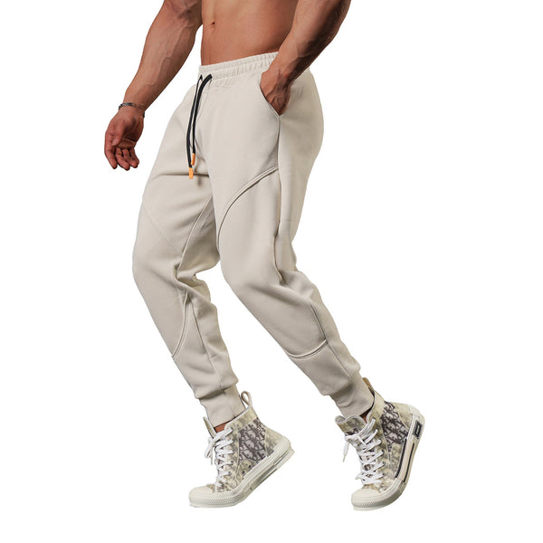 Man in beige joggers en sneakers met slangenprint, sportieve kleding, casual mode, comfortabele broek, trendy herenkleding, fitnessstijl.