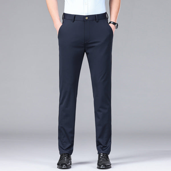 Man in donkerblauwe zakelijke broek, handen in zakken, witte blouse, zwarte schoenen. Stijlvolle herenkleding, formele outfit, modeaccessoires.