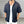 Man in zwarte gehaakte blouse met korte mouwen en witte tanktop, voor grijze achtergrond. Modieuze zomerkleding, casual stijl.