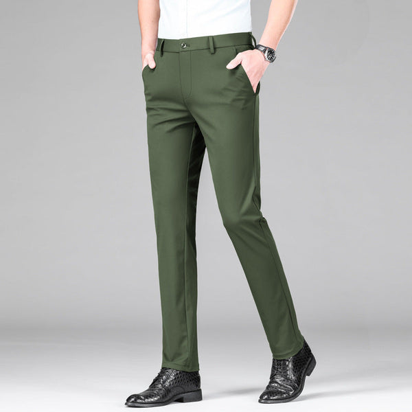 Groene herenbroek, slank fit, gedragen met zwarte leren schoenen en wit overhemd. Stijlvolle zakelijke kleding voor mannen.