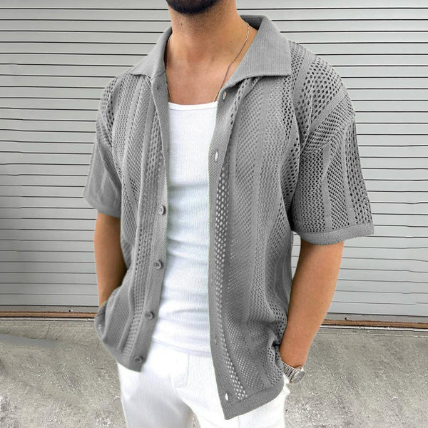 Grijze gehaakte herenoverhemd met korte mouwen, gedragen over een wit T-shirt. Stijlvolle zomermode, casual en ademend ontwerp.