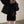 Vrouw in zwarte wollen jas en geribde jurk maakt selfie in minimalistische kamer. Modieuze winterkleding, trendy damesmode, casual stijl.