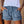 Vrouw draagt casual denim shorts met rafelige zoom en elastische tailleband, gecombineerd met een witte top. Perfect voor zomermode en casual outfits.
